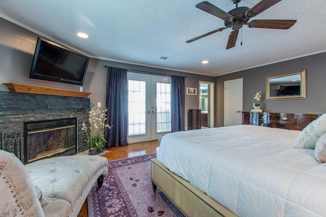 bedroom featuring visible vents, ornamental molding, access to outside, french doors, and a fireplace