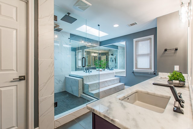 bathroom featuring visible vents, vanity, and a marble finish shower