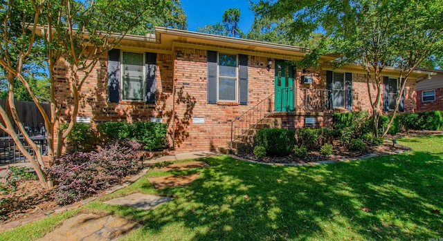 ranch-style house featuring brick siding, fence, and a front yard