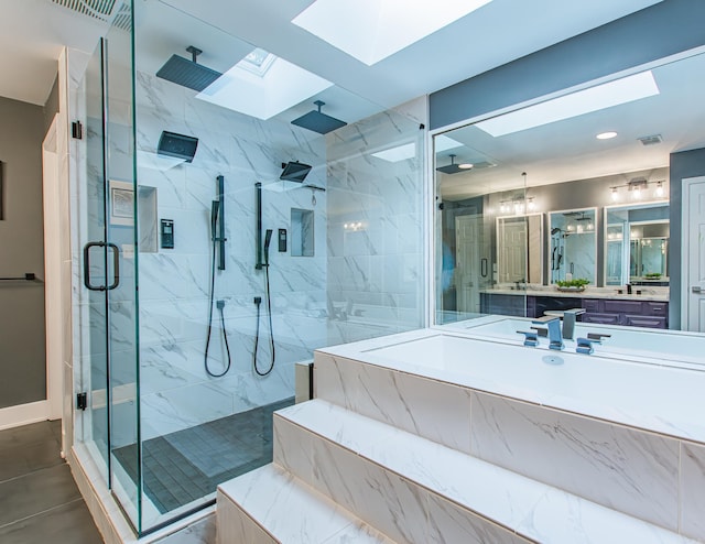 full bath featuring a skylight, a marble finish shower, visible vents, and vanity