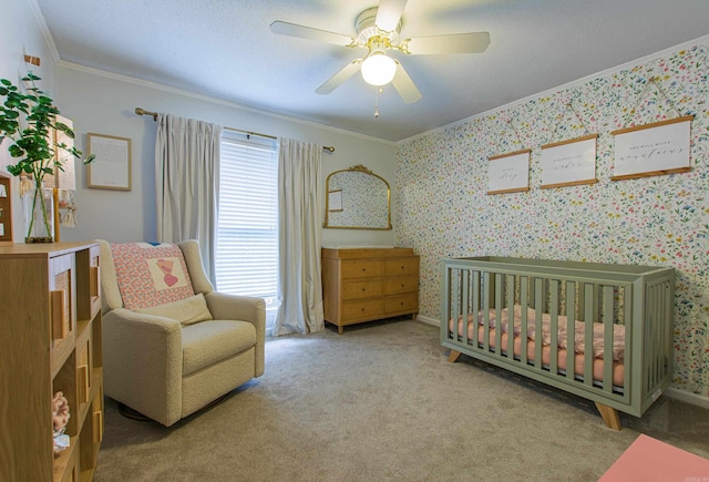 carpeted bedroom featuring a crib, wallpapered walls, a ceiling fan, and crown molding