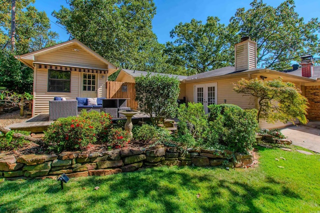 view of yard featuring a deck, french doors, and an attached garage