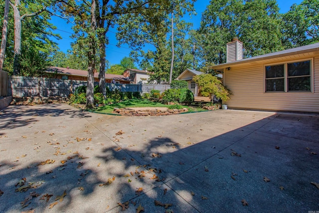 back of property featuring a chimney, fence, and a patio