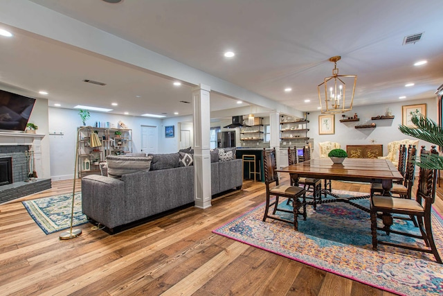 dining space with visible vents, a fireplace, hardwood / wood-style flooring, and recessed lighting