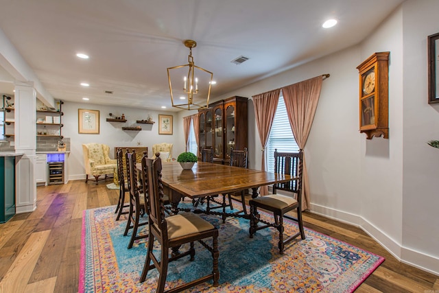 dining area featuring wine cooler, wood-type flooring, visible vents, and baseboards