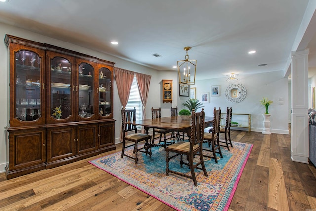 dining room with decorative columns, baseboards, wood-type flooring, and recessed lighting