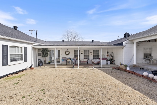 back of property with a patio area and a shingled roof