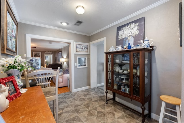 interior space featuring baseboards, visible vents, ornamental molding, tile patterned floors, and a textured ceiling