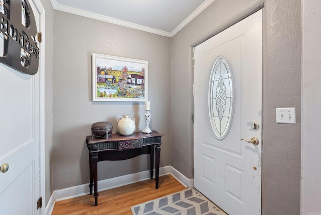 entryway featuring ornamental molding, light wood-type flooring, and baseboards