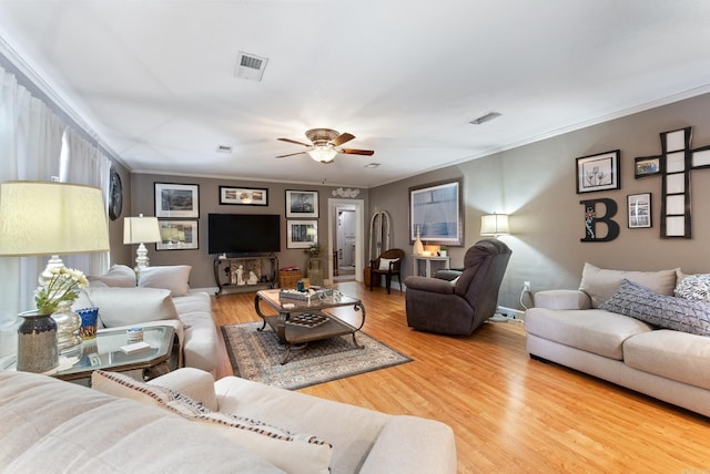 living area featuring visible vents, wood finished floors, and ornamental molding