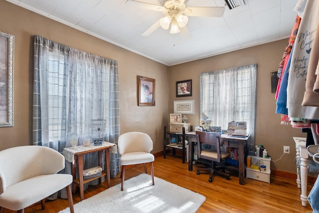 office space featuring baseboards, visible vents, wood finished floors, and ornamental molding