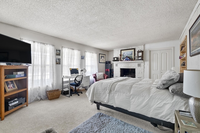 bedroom with a closet, a brick fireplace, carpet flooring, and a textured ceiling