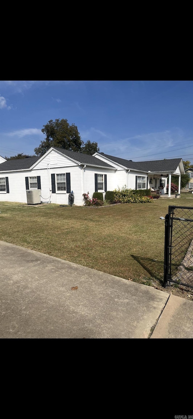 ranch-style house featuring a front yard and a gate