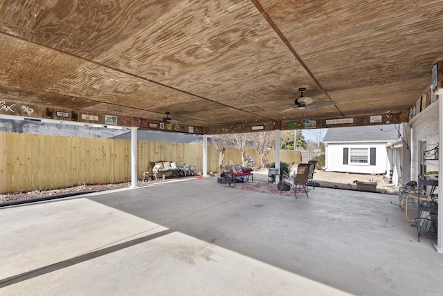 view of patio featuring fence, an outdoor structure, and ceiling fan