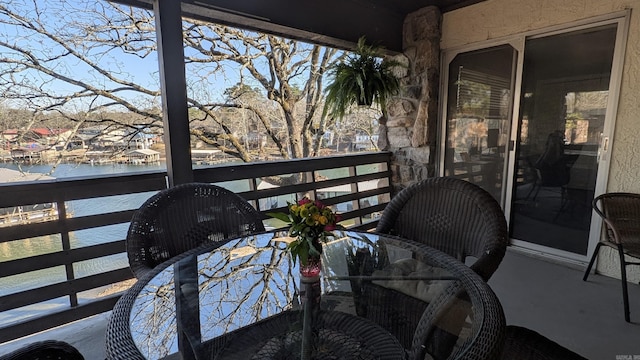 balcony with a water view and outdoor dining space