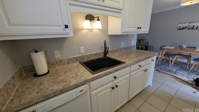 kitchen featuring crown molding, light countertops, white cabinets, white dishwasher, and a sink