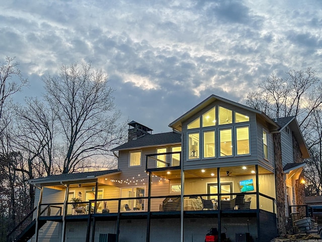 back of house at dusk with a chimney