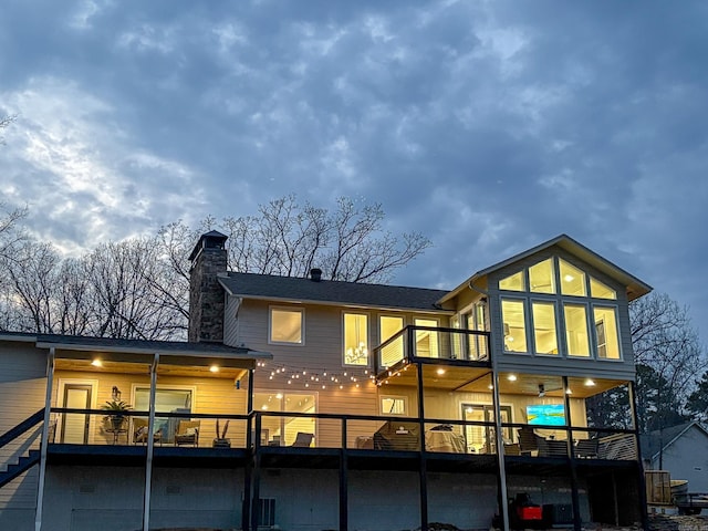 back of property featuring a chimney and a balcony