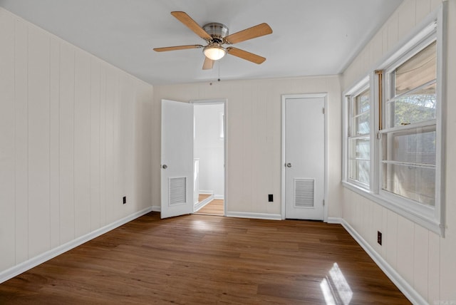 unfurnished bedroom with baseboards, visible vents, and wood finished floors