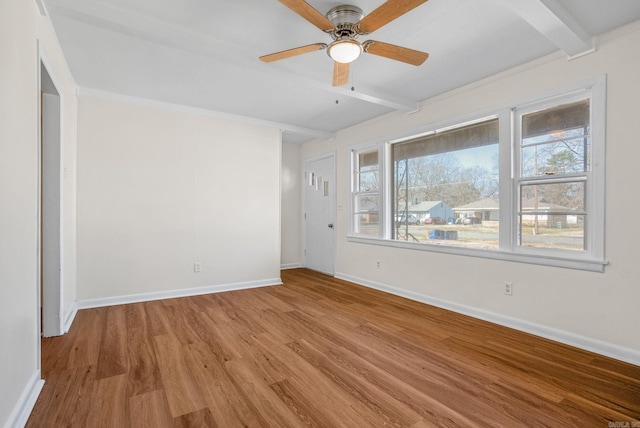 empty room with a ceiling fan, baseboards, beam ceiling, and wood finished floors