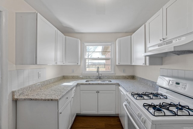 kitchen featuring white gas range oven, a sink, white cabinetry, and under cabinet range hood