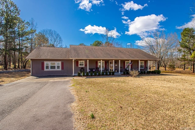 ranch-style home featuring driveway, a front lawn, and a porch