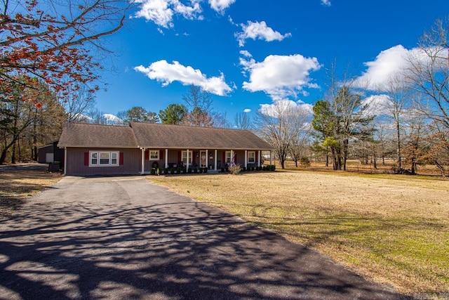 ranch-style house featuring aphalt driveway, a front lawn, and a porch