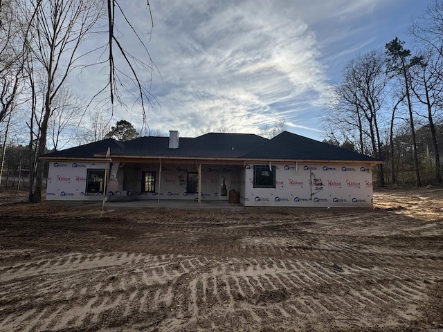 property in mid-construction with a chimney and a patio area