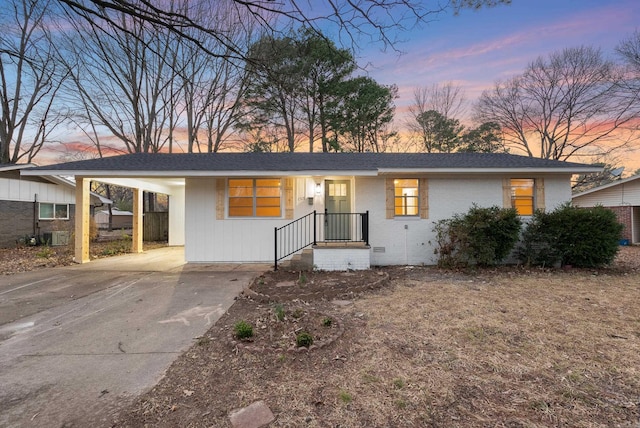 single story home with concrete driveway, roof with shingles, crawl space, a carport, and brick siding