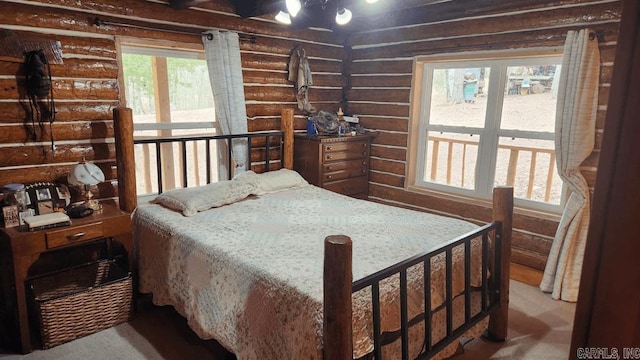 bedroom featuring carpet flooring and log walls