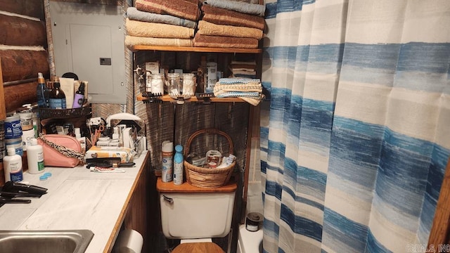 bathroom featuring toilet, curtained shower, and electric panel