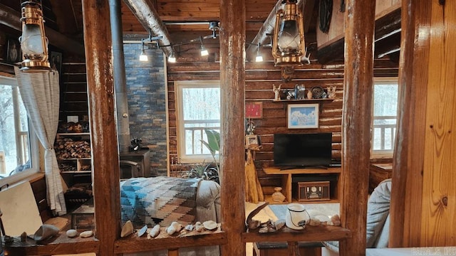 interior space featuring wooden ceiling, log walls, and beam ceiling