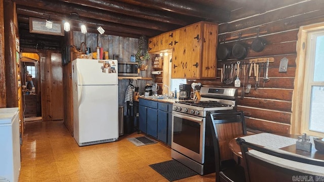 kitchen with light floors, light countertops, appliances with stainless steel finishes, a sink, and washer / dryer