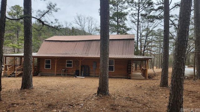 back of property with metal roof and log exterior