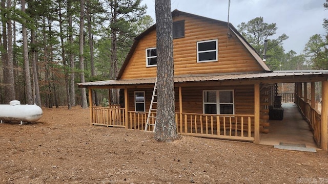 back of property featuring covered porch, metal roof, and a gambrel roof