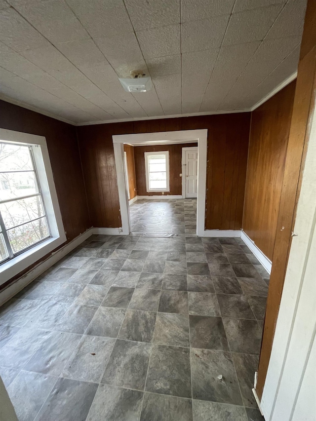 spare room with wooden walls and baseboards