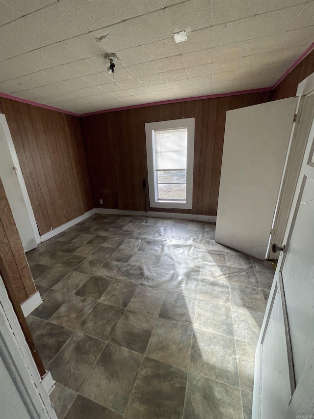 empty room with wooden walls and baseboards