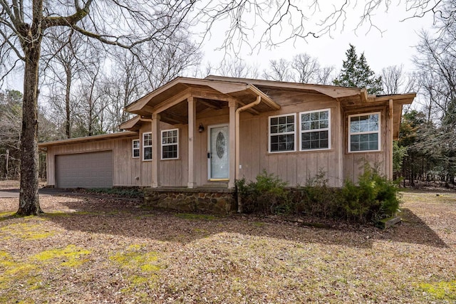 view of front of home with a garage and dirt driveway