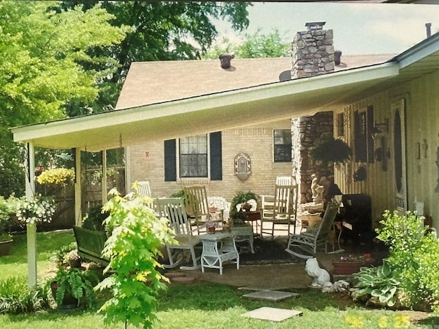 rear view of house with a patio and a chimney