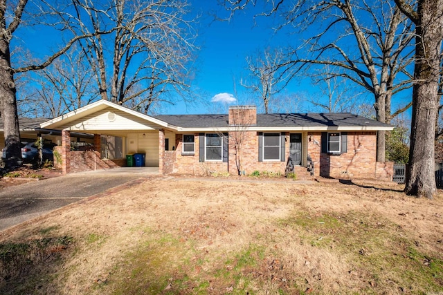 view of front facade featuring a carport, driveway, brick siding, and a chimney