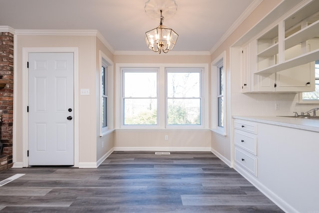 foyer featuring dark wood-style floors, baseboards, a notable chandelier, and crown molding