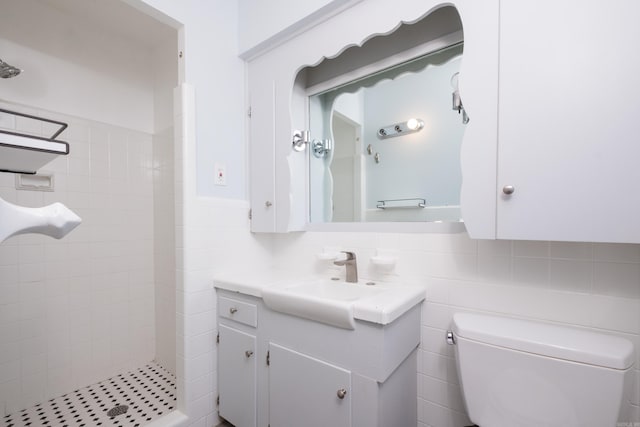 full bathroom with toilet, a stall shower, tile walls, and vanity