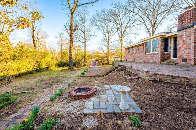 view of yard with an outdoor fire pit and a patio area