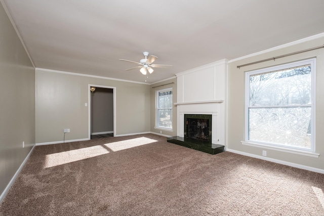 unfurnished living room with dark colored carpet, a healthy amount of sunlight, and crown molding