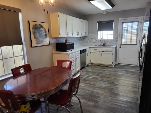 kitchen featuring stainless steel appliances, dark wood-style flooring, a sink, and white cabinets