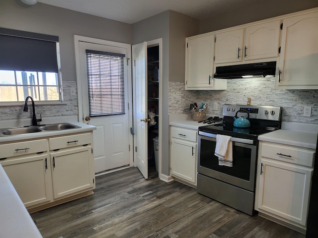 kitchen featuring stainless steel range with electric cooktop, a sink, white cabinets, and under cabinet range hood