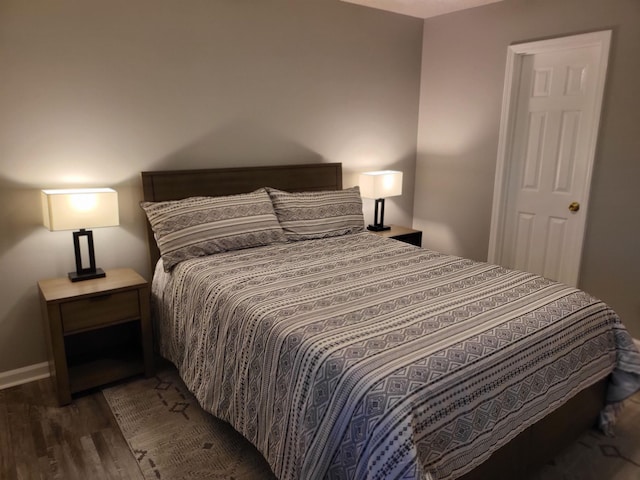 bedroom with wood finished floors and baseboards