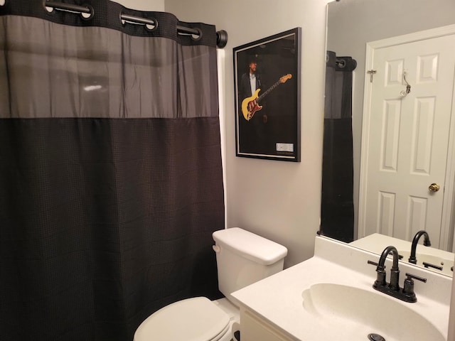 bathroom with toilet, a shower with shower curtain, and vanity