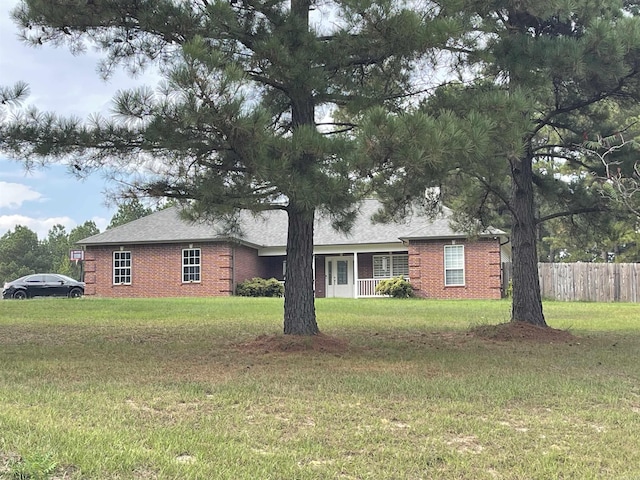 ranch-style home featuring fence, a front lawn, and brick siding