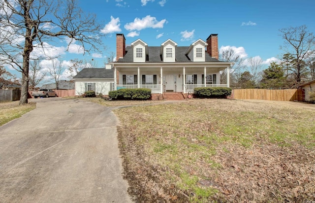 cape cod house featuring a chimney, fence, and a porch